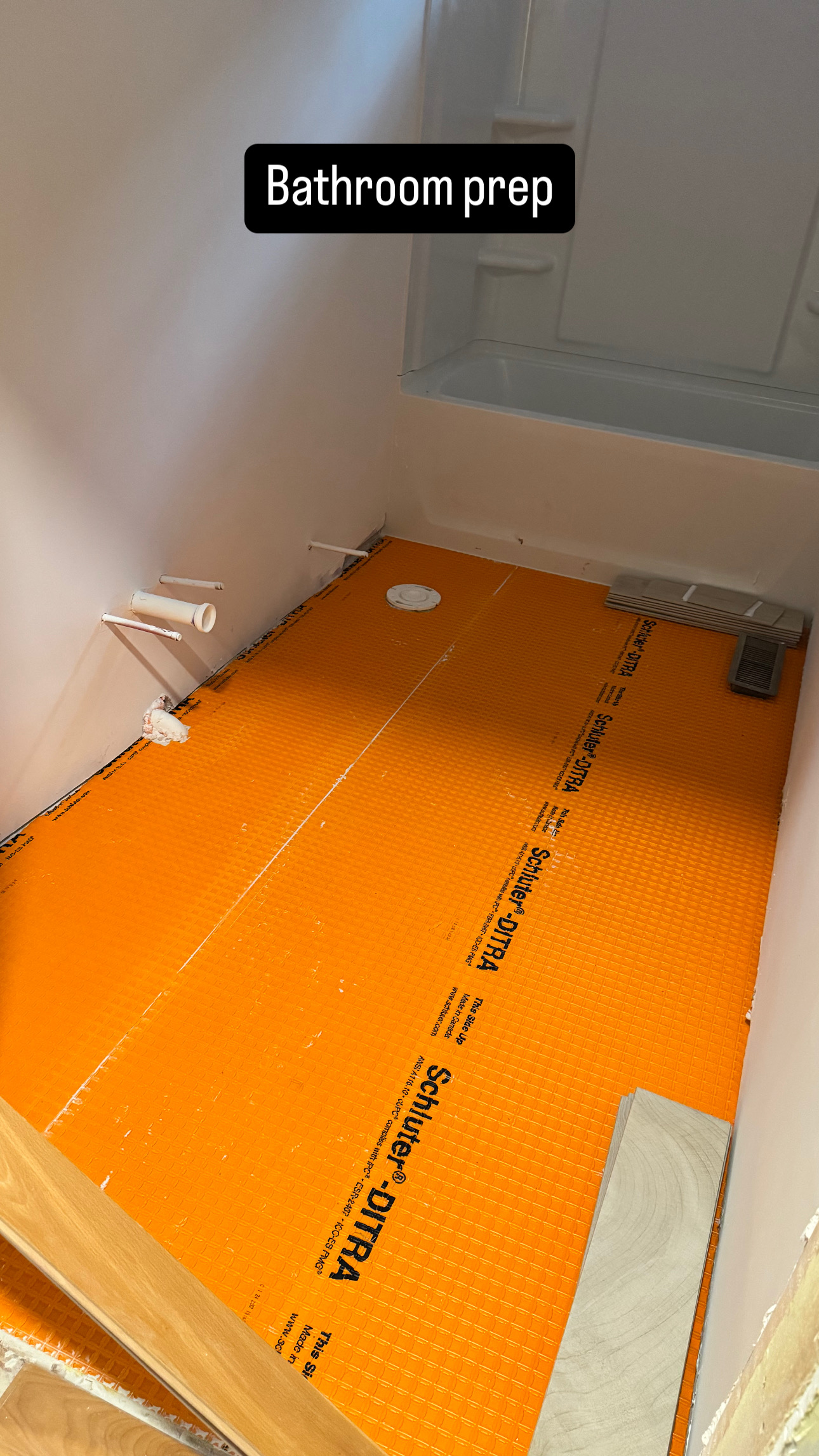 Bathroom floor waterproofing with Schluter DITRA membrane, shower pan, and plumbing rough-ins